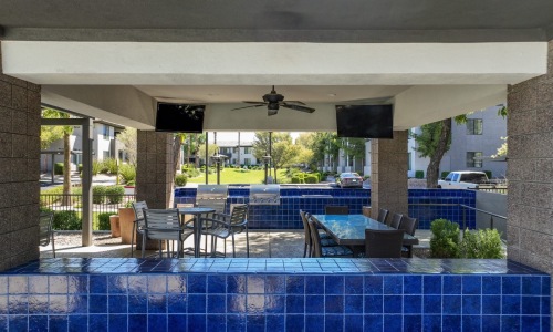 outdoor covered patio with seating and tvs