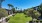 a green lawn with trees and buildings