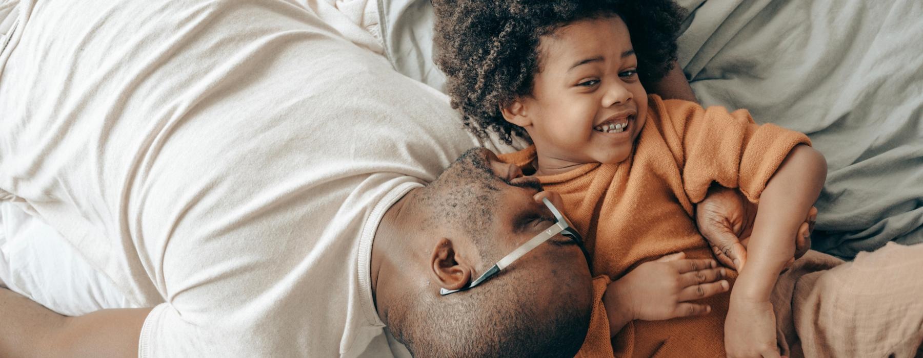 a person and a child lying in bed