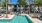 a swimming pool with trees and a building in the background
